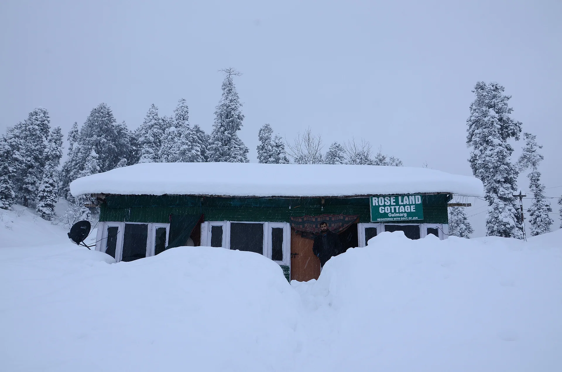 A snow-covered hut buried in deep winter snow at Gulmarg