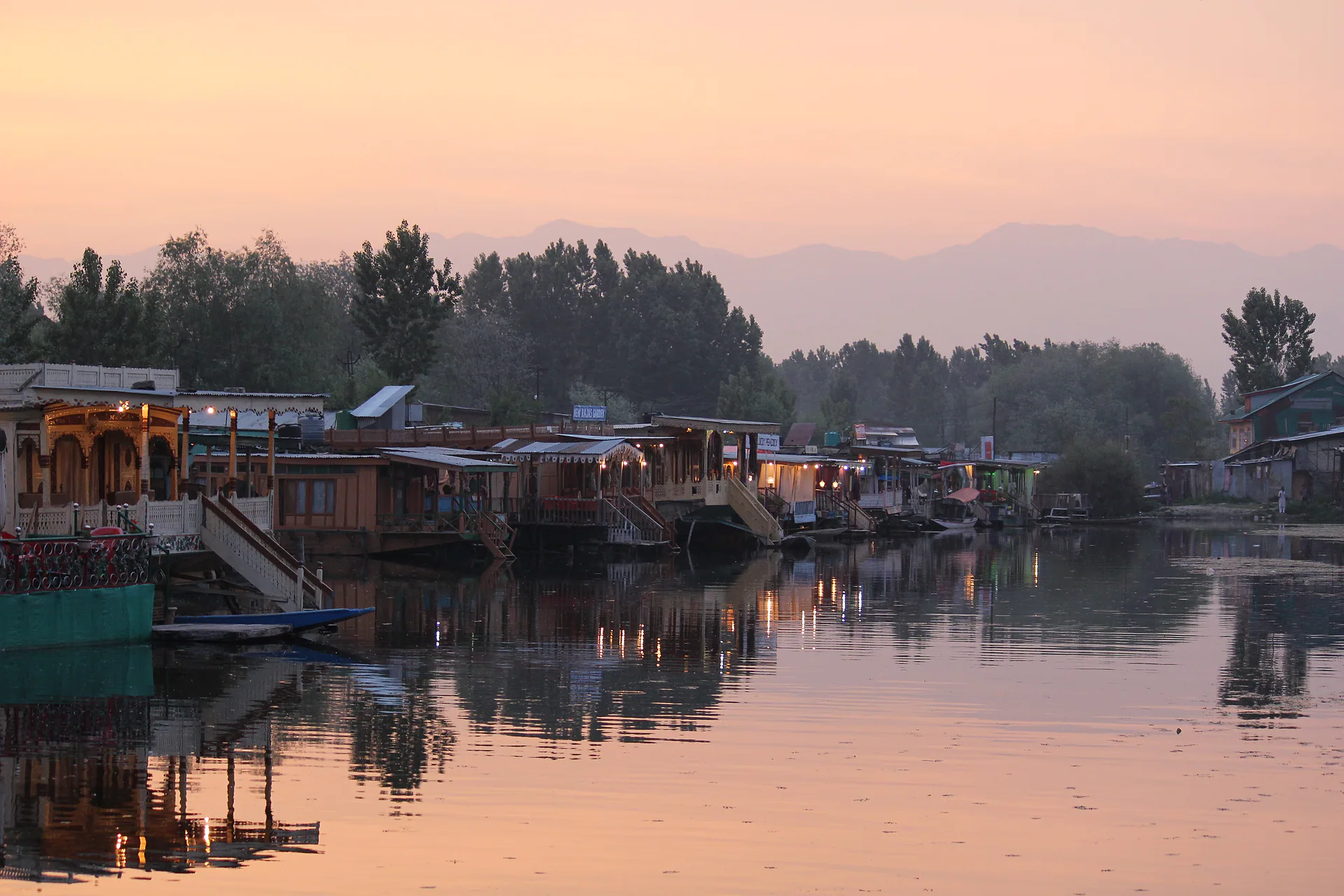 Houseboats on Dal Lake glowing in soft evening light